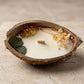 Nahaufnahme der handgefertigten Kokoskerze Coco Bloom von Kristalla in natürlicher Kokosnussschale mit Holzdocht und Sojawachs