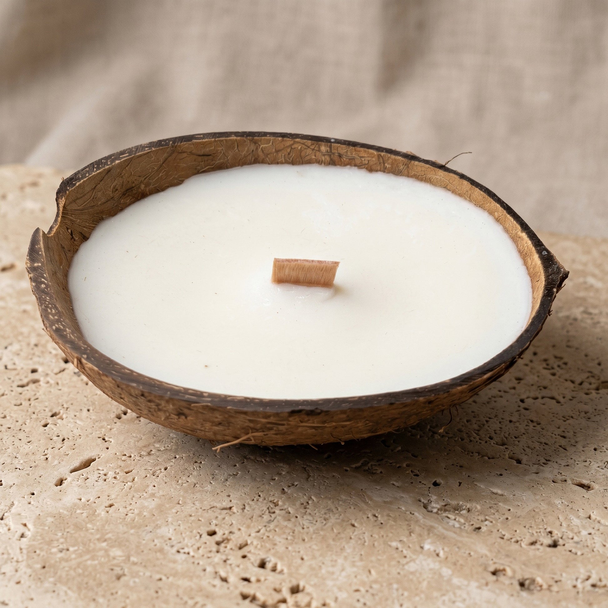 Nahaufnahme der handgefertigten Kokoskerze Coco Dream von Kristalla in natürlicher Kokosnussschale mit Holzdocht und Sojawachs