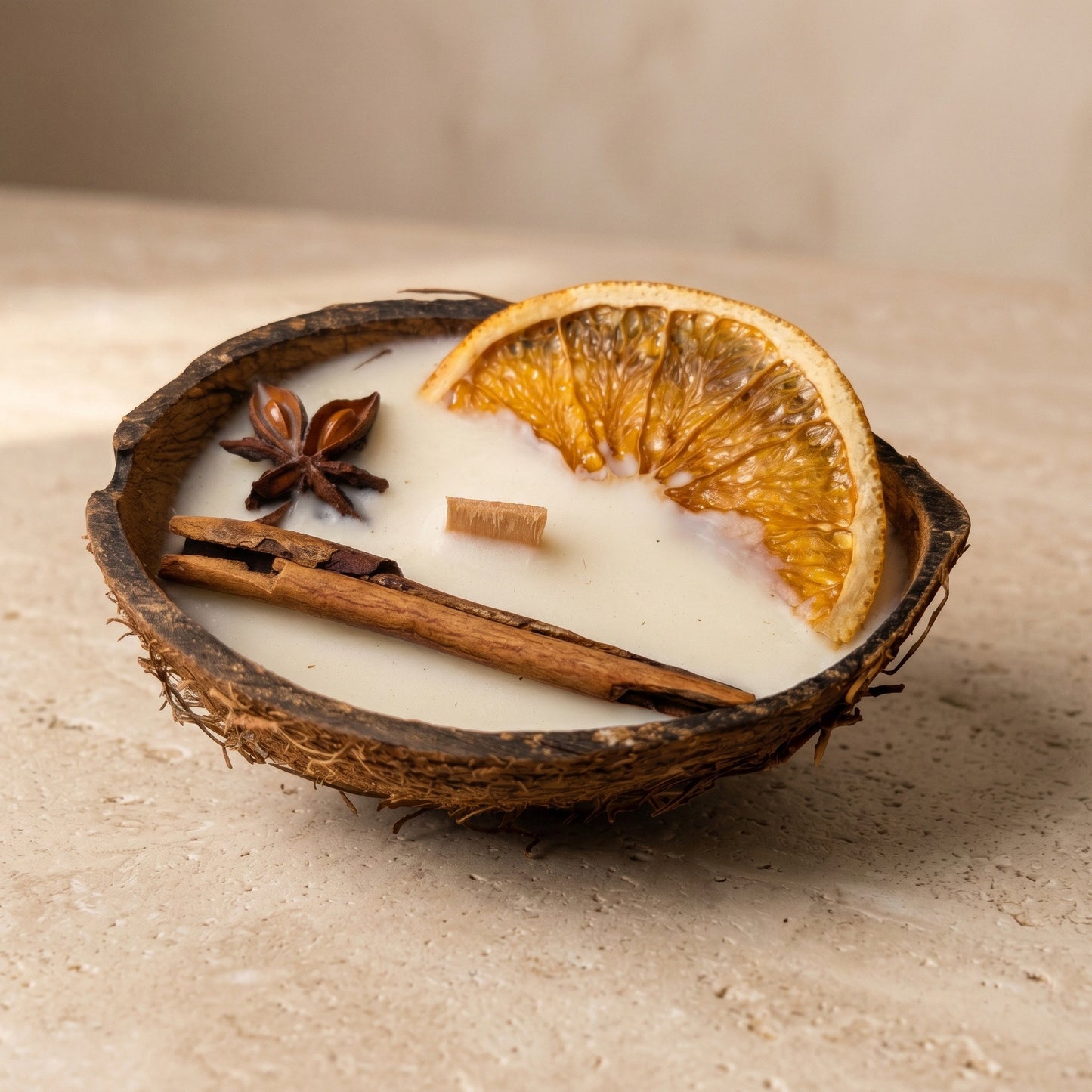 Nahaufnahme der handgefertigten Kokoskerze Coco Spice von Kristalla in natürlicher Kokosnussschale mit Holzdocht und Sojawachs