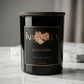 Nahaufnahme der Premium Duftkerze Black Amber von Kristalla im schwarzen Glas mit Holzdeckel
